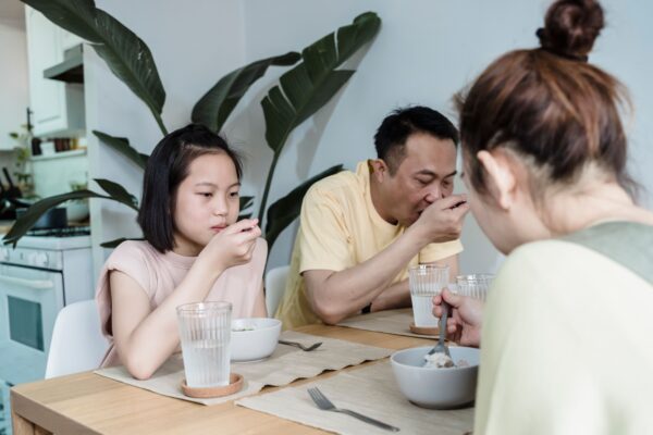 Family with children eating breakfast together at a hotel restaurant table