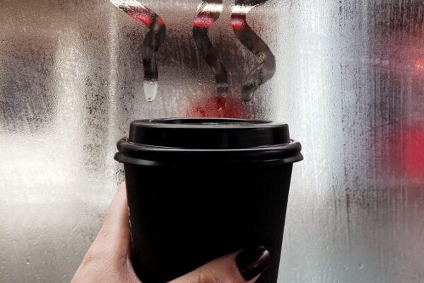Hand holding a takeaway coffee cup, illustrating the Starbucks Rewards changes to UK Star pricing