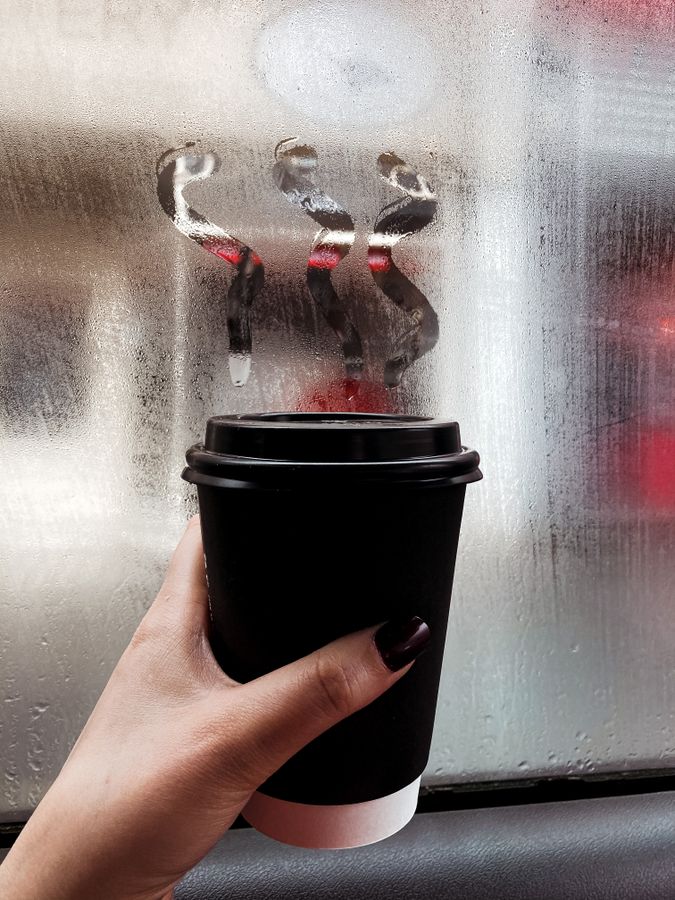 Hand holding a takeaway coffee cup, illustrating the Starbucks Rewards changes to UK Star pricing